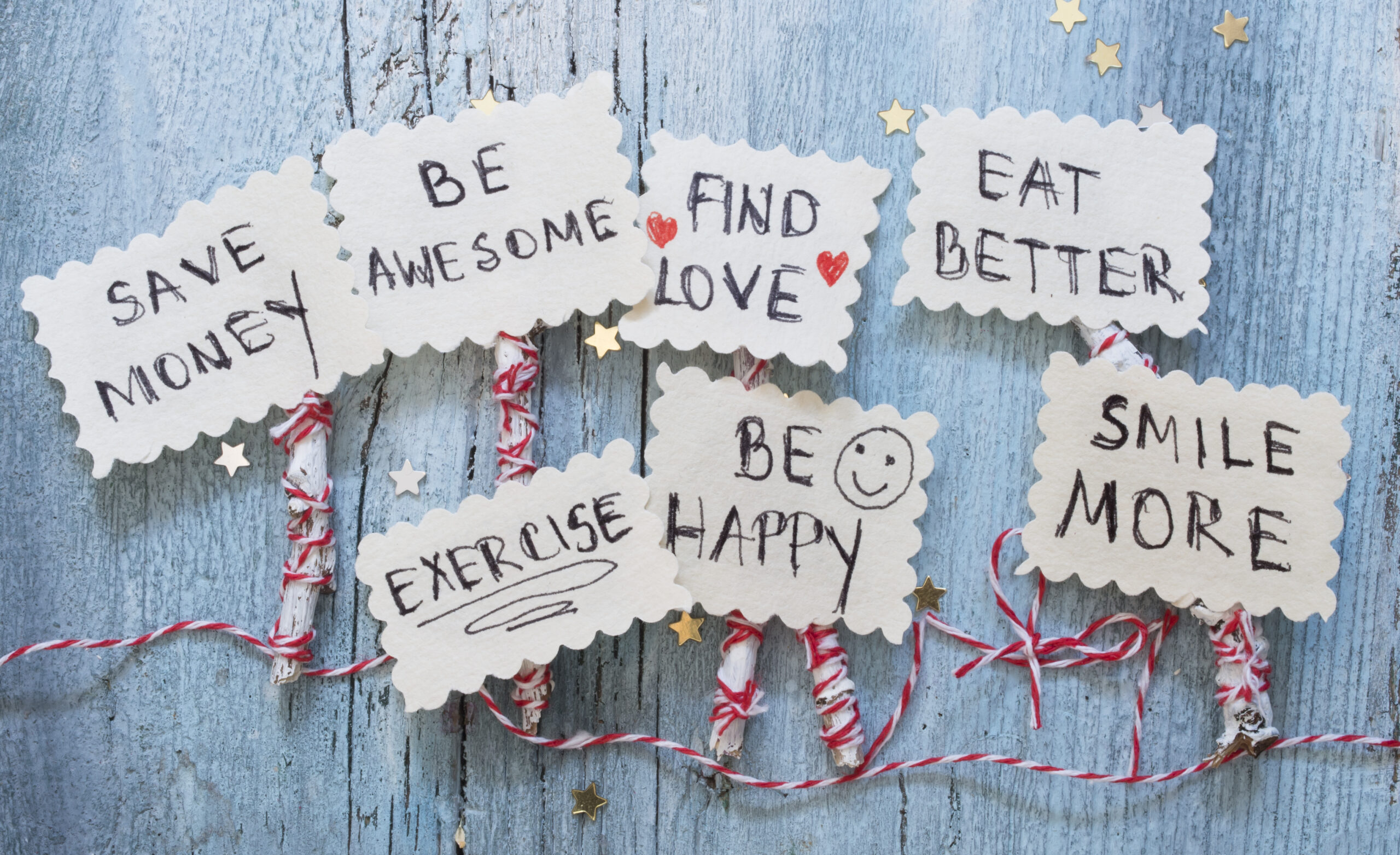 image of handwritten notes with various new years resolution statements: save money, be awesome, find love, eat better, exercise, be happy, smile more