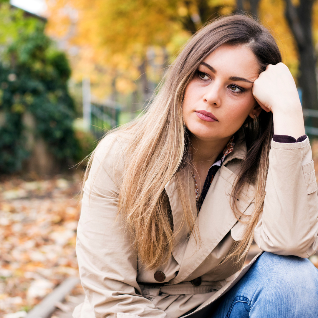 women sitting in woods sad