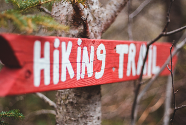 red sign with white letters that says hiking trail